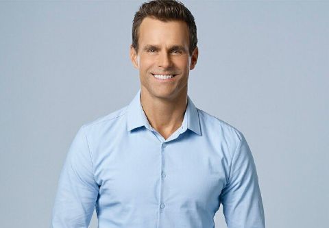 Cameron Mathison in a blue shirt poses for a picture.